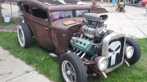 The rust surface finish, few mufflers on the exhaust headers and Punisher spray painted in the grill are clues that this car is all about fun and is a rat rod